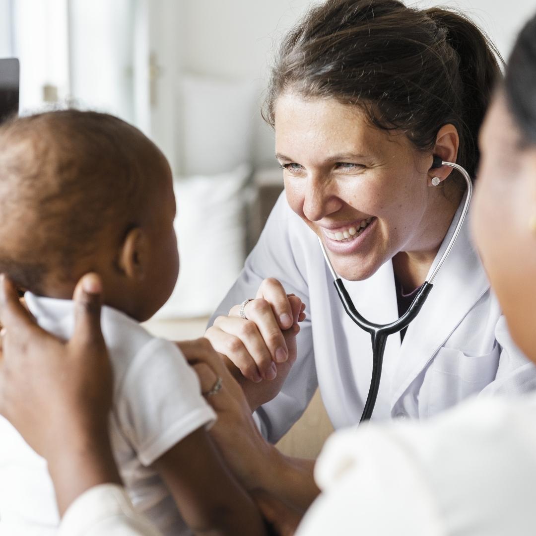Smiling doctor with infant patient